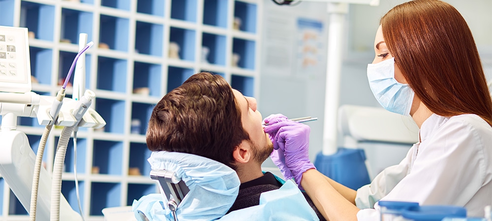Professional woman dentist doctor working . man at dental clinic. man at dentist taking care of teeth.Dental care for people. Dentist holding dental device for fixing teeth.