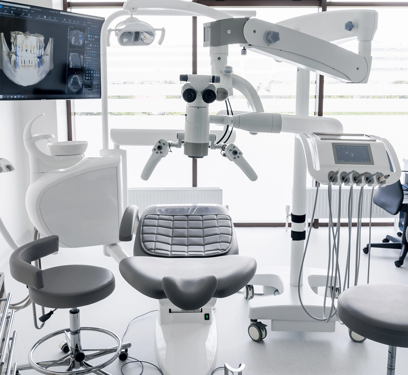 Interior of dental practice room with chair, lamp, display and stomatological tools