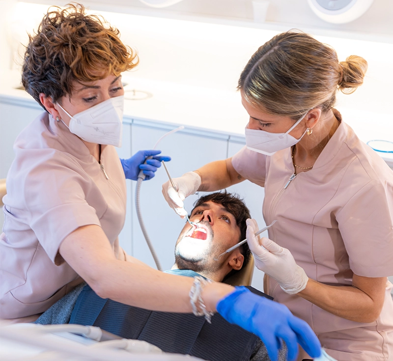 Young man Checking the teeth at the dentist office attended by two technician
