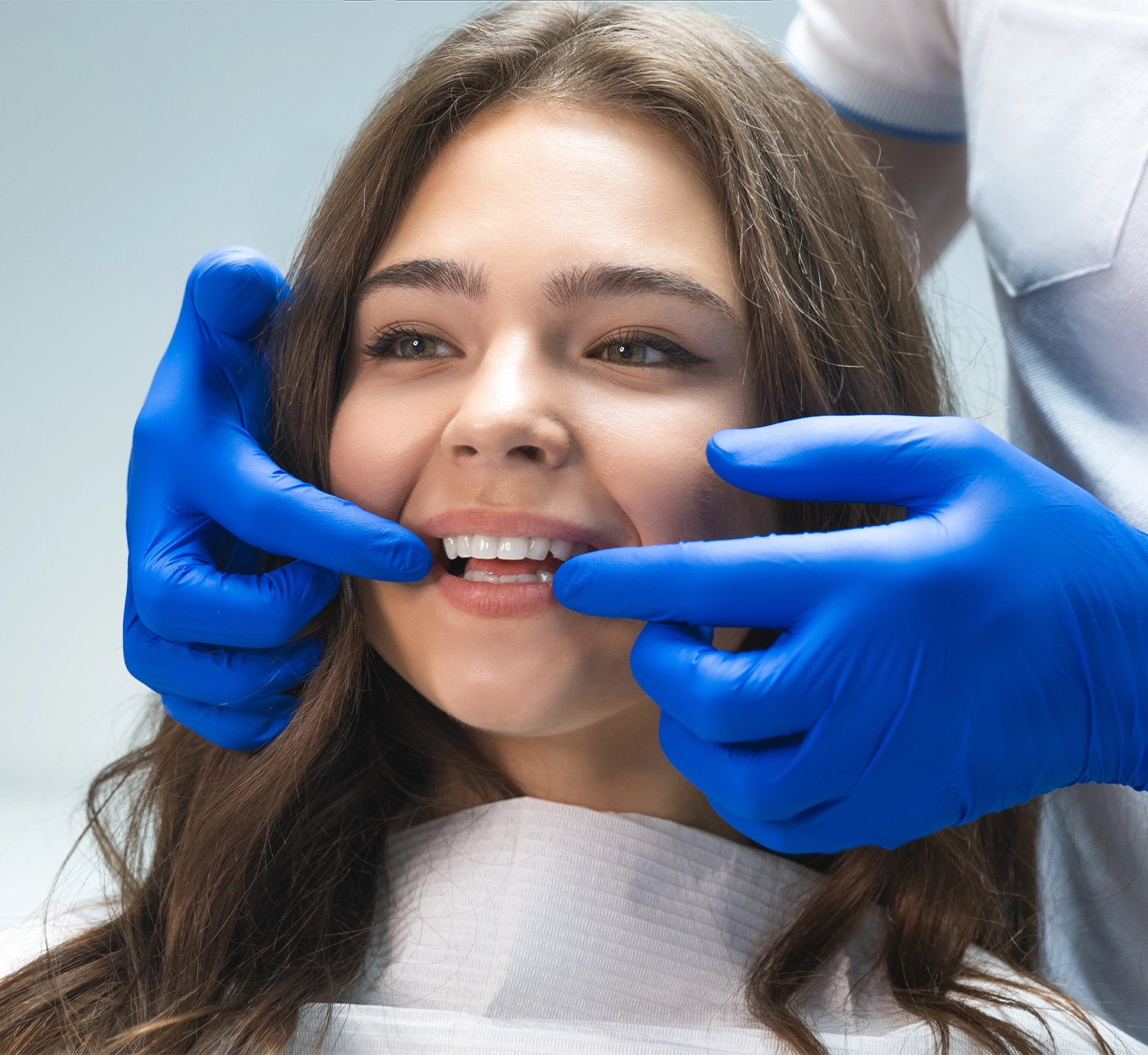 beautiful young brunette woman having examination at dental office while dentist showing whitening results to happy patient